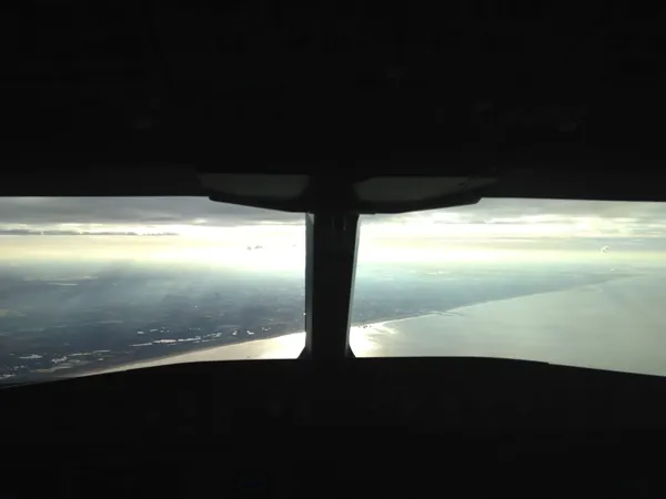 Left of the cockpit window divider: the high-rises of The Hague. Just to the right: Scheveningen Pier. Farther right: the entrance to Scheveningen harbor. In the far distance: Hoek van Holland and the Rotterdam Maasvlakte.