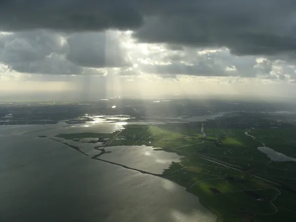 Amsterdam beyond shafts of sunlight breaking through the clouds.