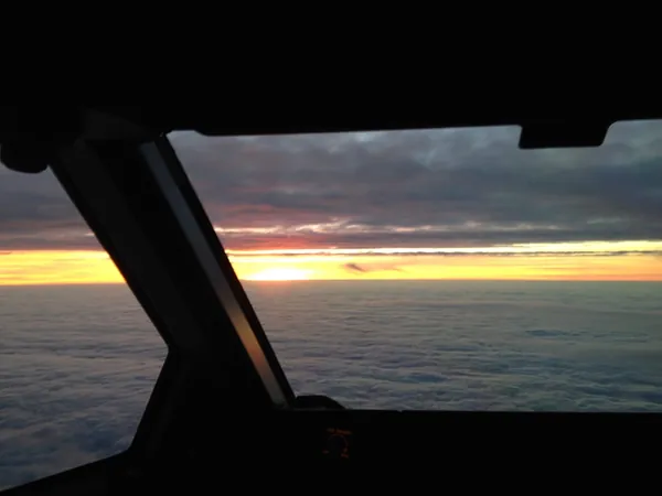 Between cloud layers during the descent, enjoying the sunrise.