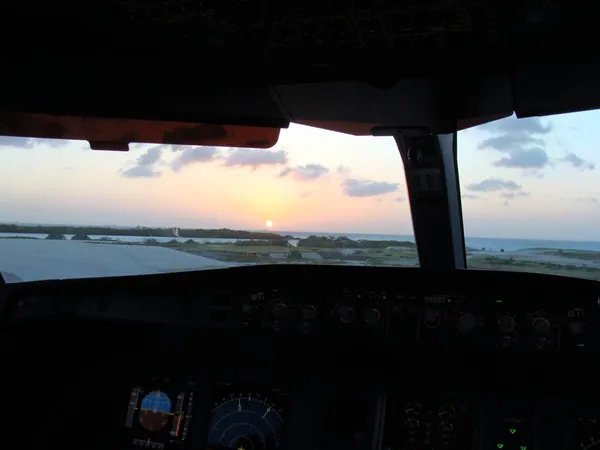 Taxiing across Aruba airport for departure to Bonaire, as the sun slowly sinks into the Caribbean Sea.